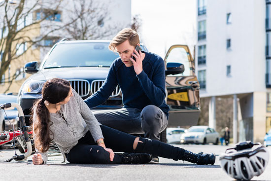 A person calling an ambulance for someone who was hit by a car