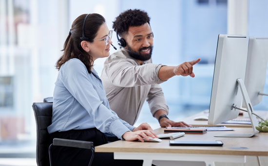 One person guides another on working on the computer