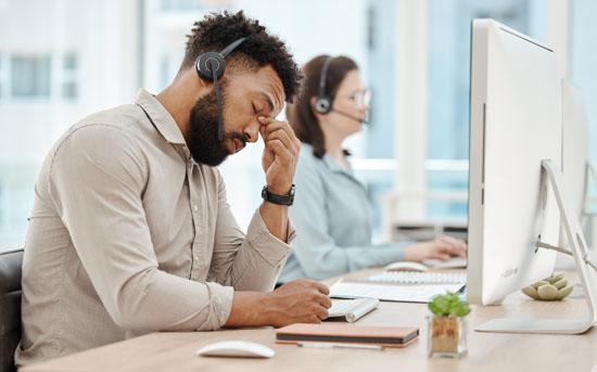 A customer service employee pinching their nose like they're stressed