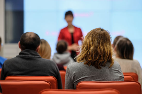 A crowd listening to a speaker at a conference