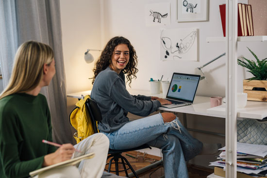 Two college students studying and smiling