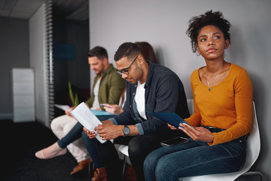 A picture of individuals sitting in a row in an office