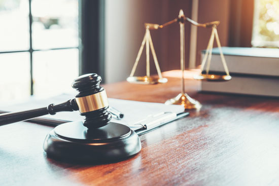 A gavel and scale resting on a surface