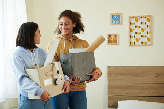 An image of two people in a college dorm room