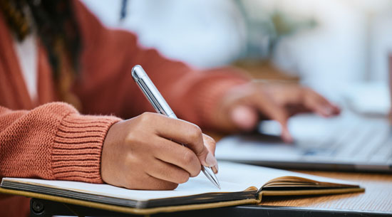 A picture of a student writing in a notebook