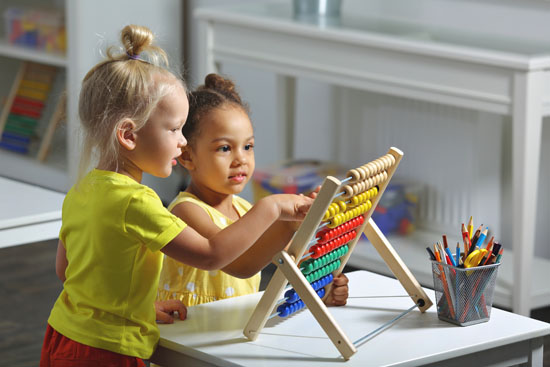 A picture of two children playing with an abacus together