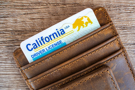 A picture of a wallet with a California driver's license sticking out of the top