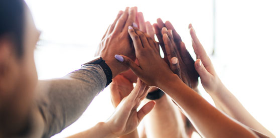 A picture of several hands joining in a joint high-five