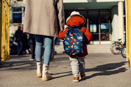 A parent walking their child into school