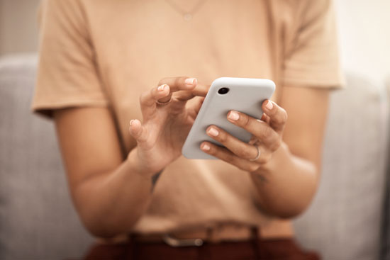 A person holding their phone, about to tap the screen