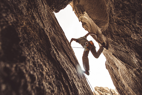 A person climbing between two large rock walls